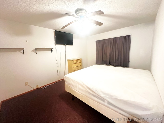 carpeted bedroom with ceiling fan and a textured ceiling