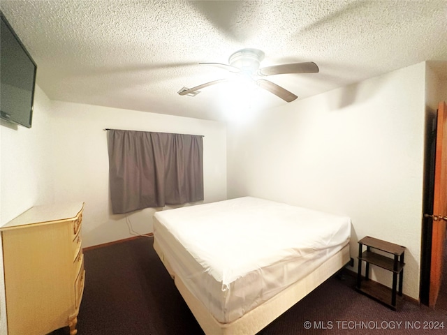 carpeted bedroom with ceiling fan and a textured ceiling