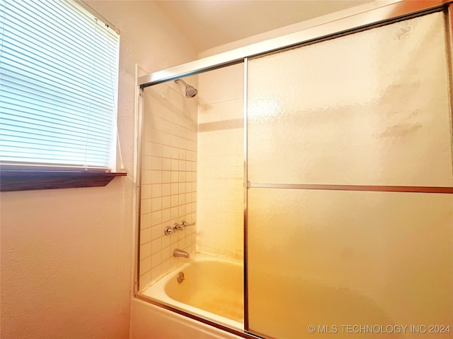 bathroom with bath / shower combo with glass door