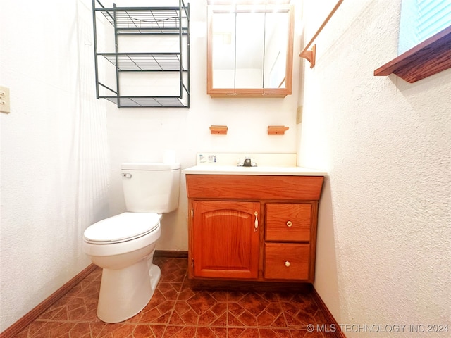 bathroom featuring tile patterned floors, vanity, and toilet