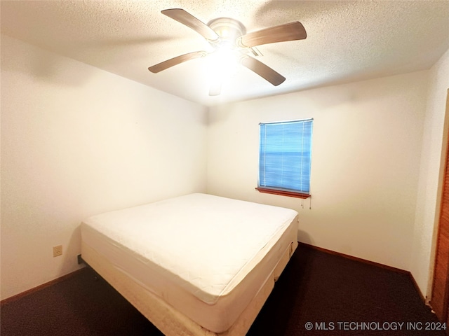 unfurnished bedroom with ceiling fan, carpet flooring, and a textured ceiling