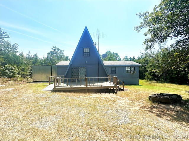 rear view of house featuring a wooden deck and a yard