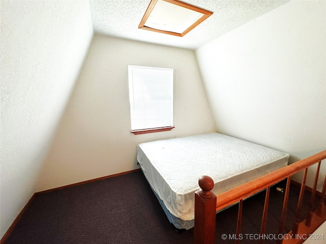 bedroom featuring a textured ceiling, carpet, and vaulted ceiling