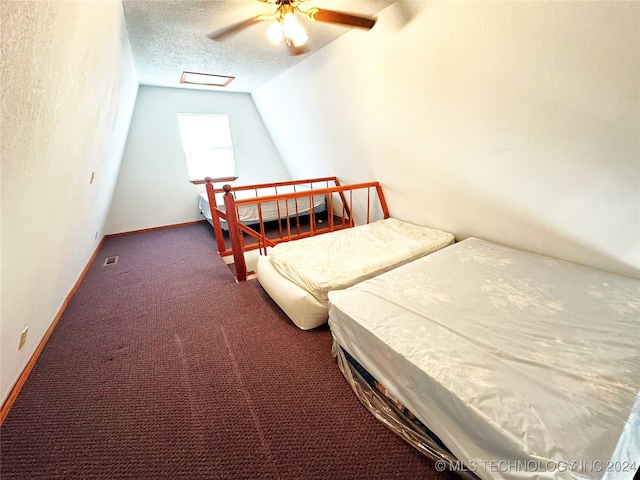 carpeted bedroom featuring ceiling fan and a textured ceiling