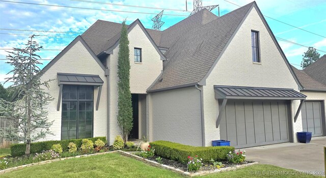 view of front of house featuring a garage and a front lawn