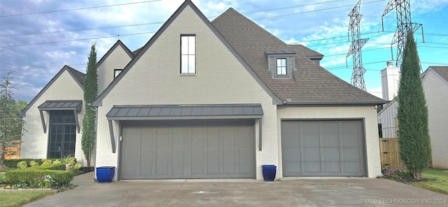 view of front of property featuring a shingled roof and brick siding