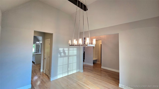 unfurnished dining area with high vaulted ceiling and light hardwood / wood-style flooring