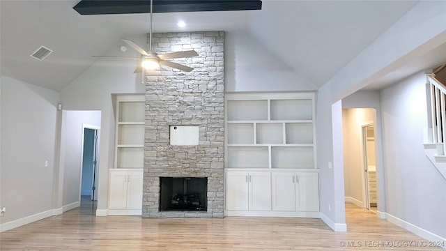 unfurnished living room featuring light hardwood / wood-style flooring, lofted ceiling with beams, ceiling fan, a fireplace, and built in features