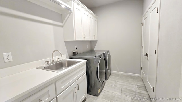 laundry area with cabinets, light tile patterned floors, sink, and washer and clothes dryer