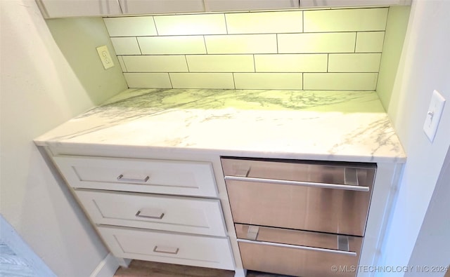 interior space featuring white cabinetry, hardwood / wood-style flooring, and light stone countertops