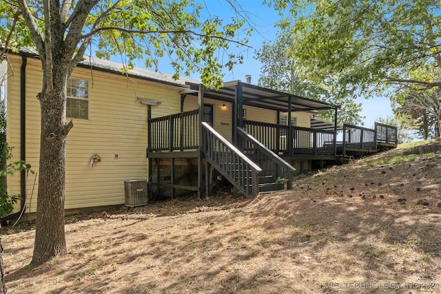 back of house with central AC unit and a wooden deck