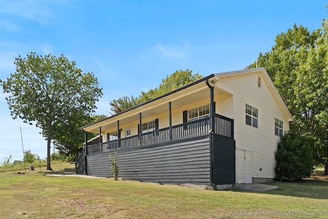 view of side of property with a balcony and a lawn