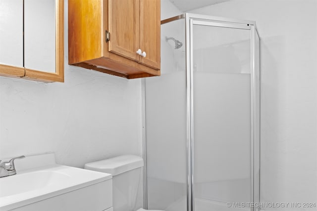 bathroom featuring walk in shower, toilet, and vanity