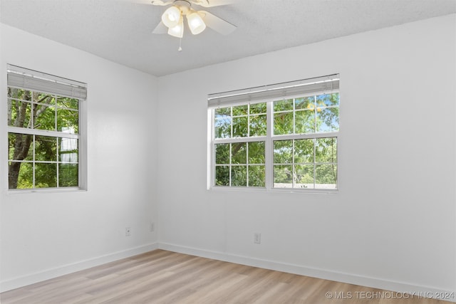 spare room with ceiling fan, a textured ceiling, and light hardwood / wood-style floors