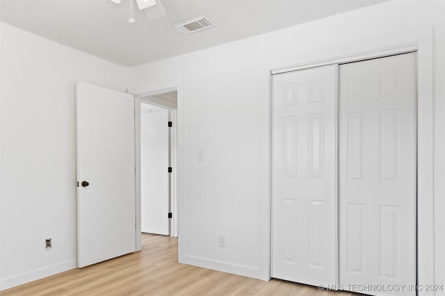 unfurnished bedroom with light hardwood / wood-style flooring, a closet, and ceiling fan