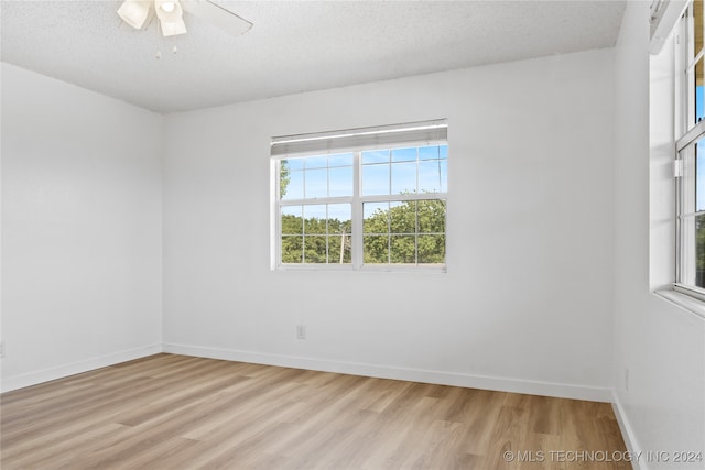 unfurnished room featuring a textured ceiling, ceiling fan, and light hardwood / wood-style floors