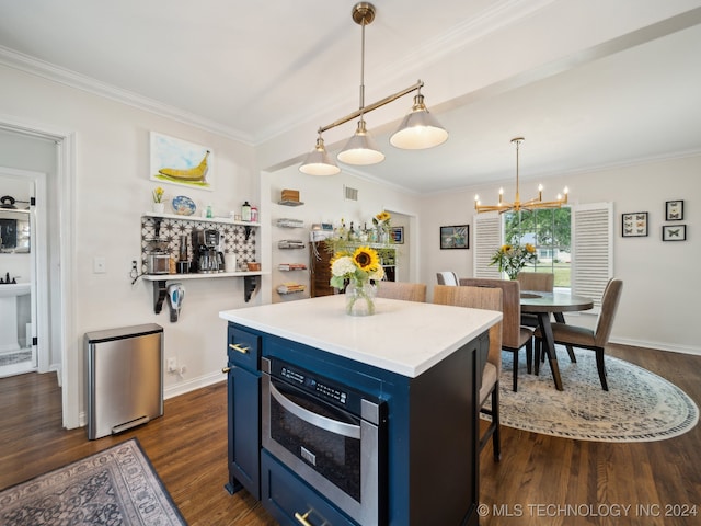 kitchen featuring dark wood-type flooring, a center island, blue cabinets, hanging light fixtures, and light countertops