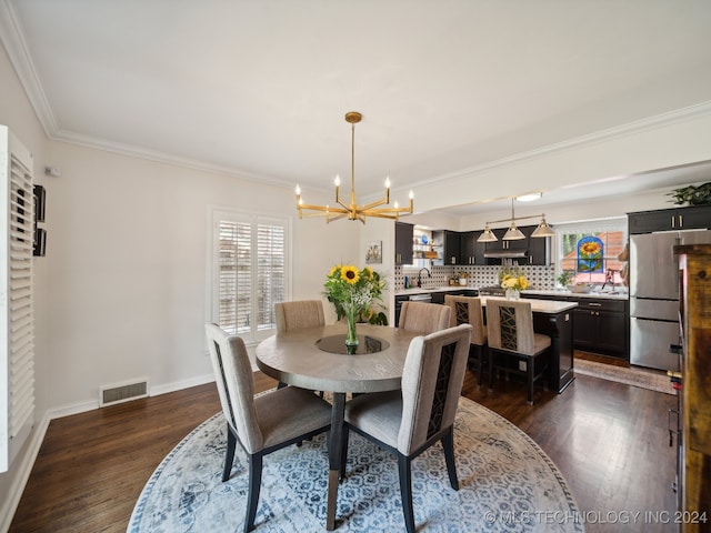 dining area featuring a notable chandelier, crown molding, visible vents, and dark wood-style flooring