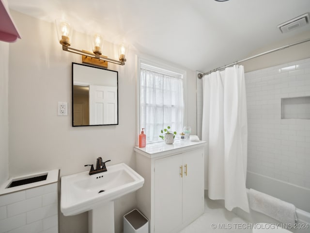 bathroom featuring a sink, visible vents, and shower / tub combo with curtain