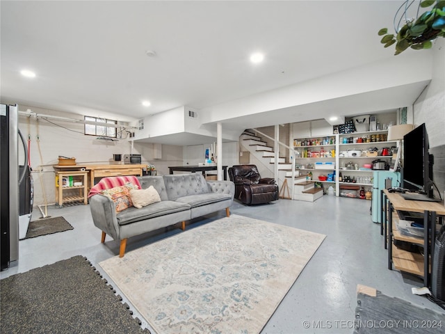 living area featuring finished concrete floors, stairway, visible vents, and recessed lighting