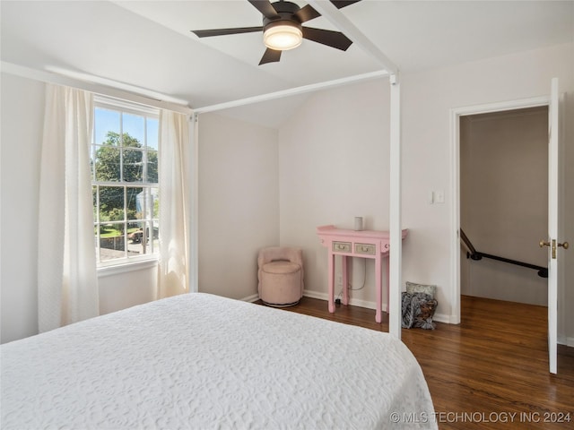 bedroom featuring lofted ceiling, dark wood-style flooring, ceiling fan, and baseboards