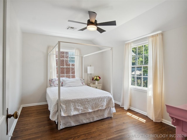 bedroom featuring baseboards, visible vents, vaulted ceiling, and dark wood-style flooring