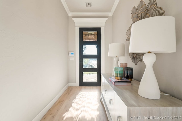 entrance foyer featuring ornamental molding and light hardwood / wood-style floors