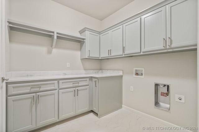 washroom featuring cabinets, hookup for an electric dryer, light tile patterned floors, and washer hookup