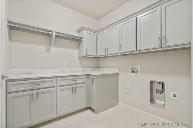clothes washing area featuring marble finish floor, baseboards, electric dryer hookup, cabinet space, and washer hookup