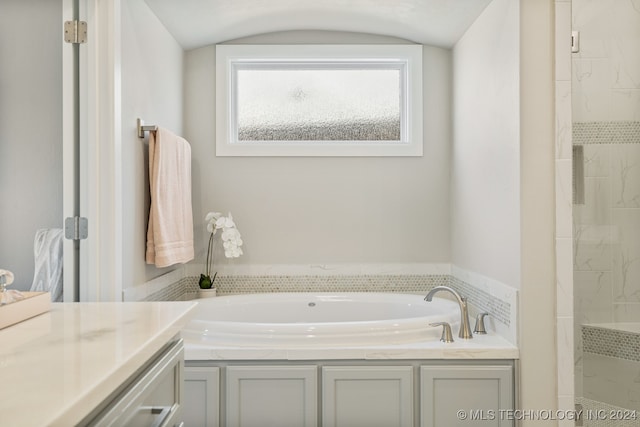 bathroom with lofted ceiling and a bath