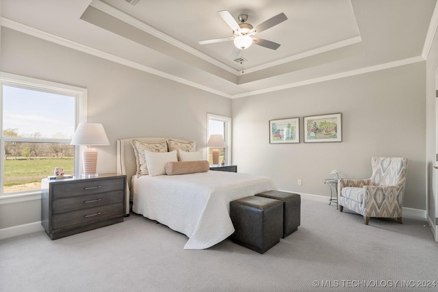 bedroom with light carpet, a raised ceiling, baseboards, ceiling fan, and ornamental molding