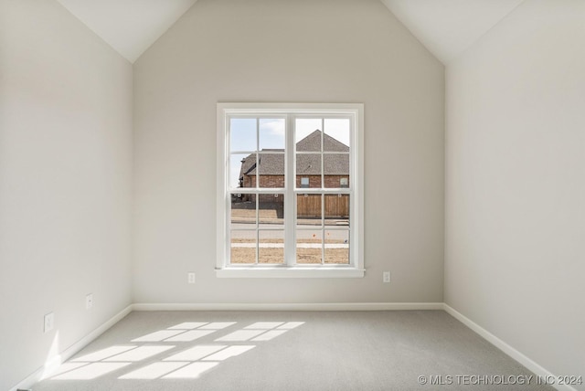 unfurnished room with vaulted ceiling, baseboards, and carpet
