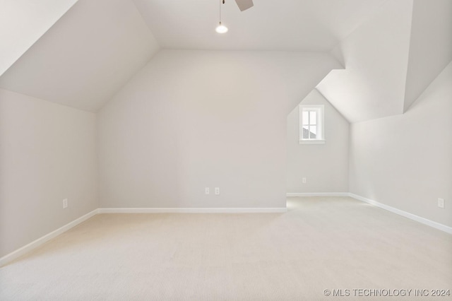 bonus room with baseboards, lofted ceiling, light colored carpet, and ceiling fan