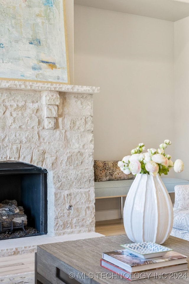interior details with wood finished floors and a stone fireplace