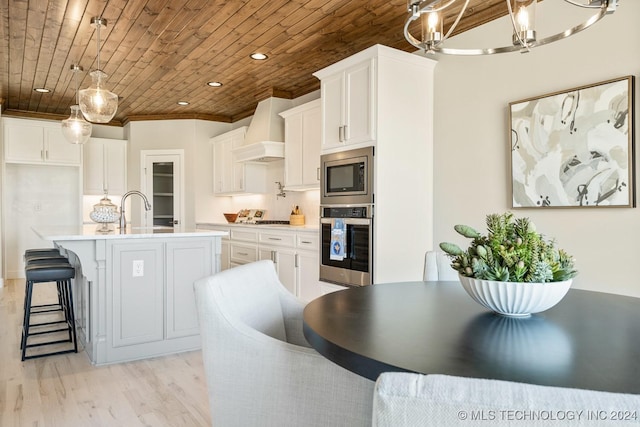 kitchen featuring premium range hood, wooden ceiling, appliances with stainless steel finishes, and light wood-type flooring