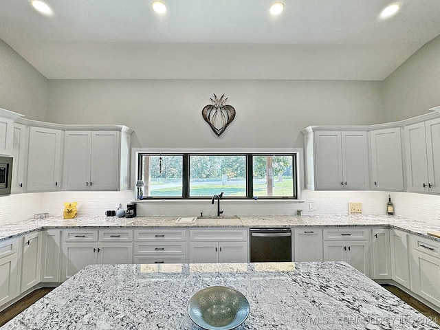 kitchen with decorative backsplash, white cabinets, stainless steel appliances, and light stone countertops