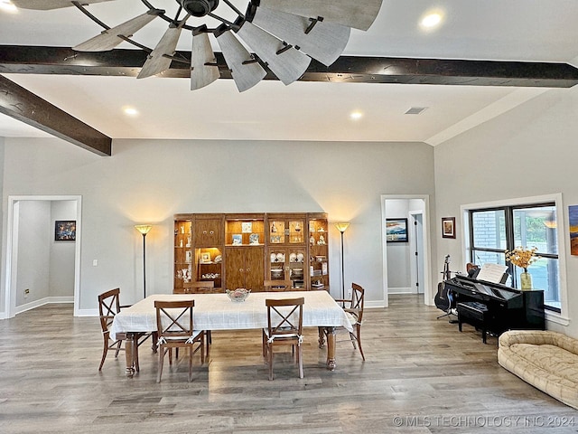 living room featuring hardwood / wood-style floors, beamed ceiling, a high ceiling, and ceiling fan