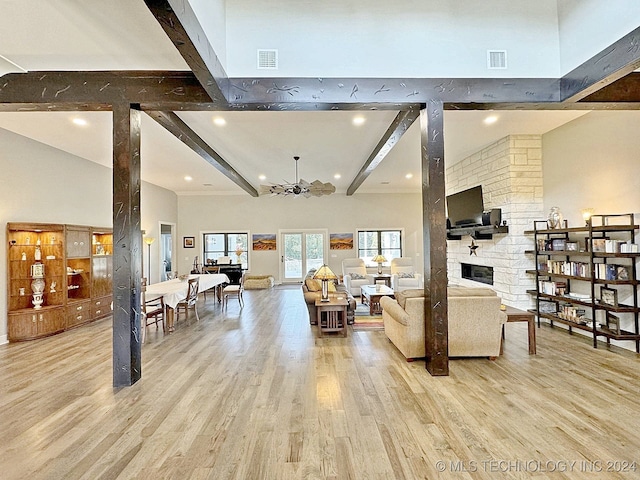 living room with a notable chandelier, light hardwood / wood-style flooring, and beamed ceiling