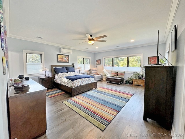 bedroom featuring an AC wall unit, crown molding, ceiling fan, and light hardwood / wood-style floors