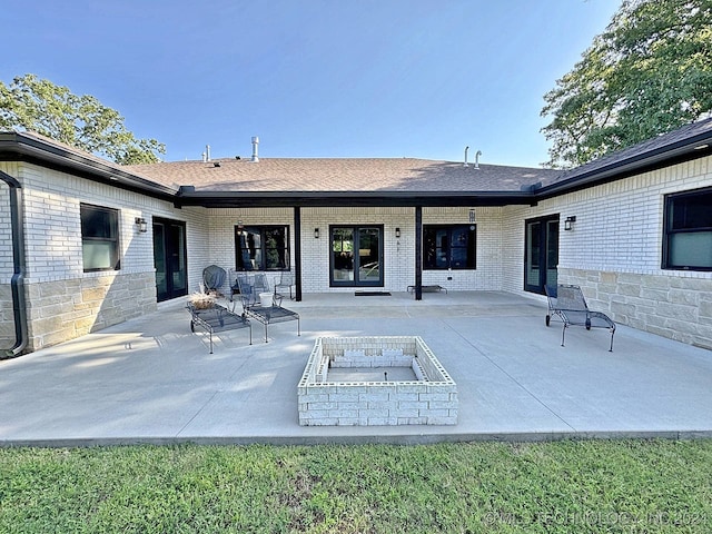 back of property with a patio and a fire pit