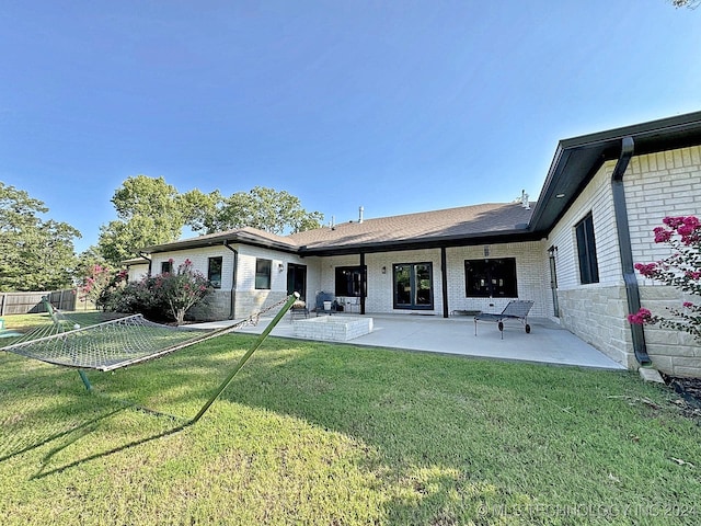 rear view of house with a patio and a yard