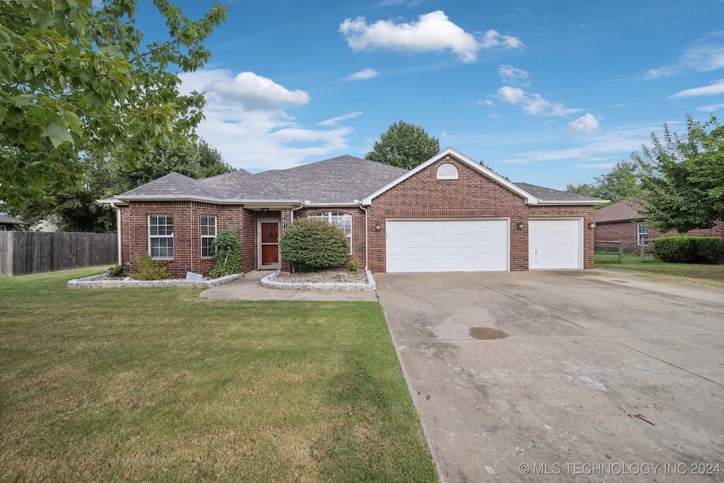 single story home featuring a garage and a front lawn