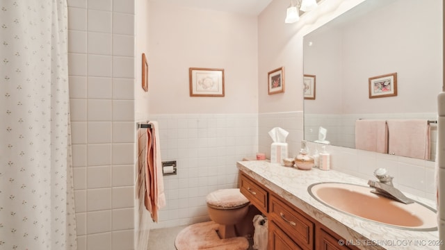 bathroom with tile walls, toilet, vanity, and a shower with shower curtain