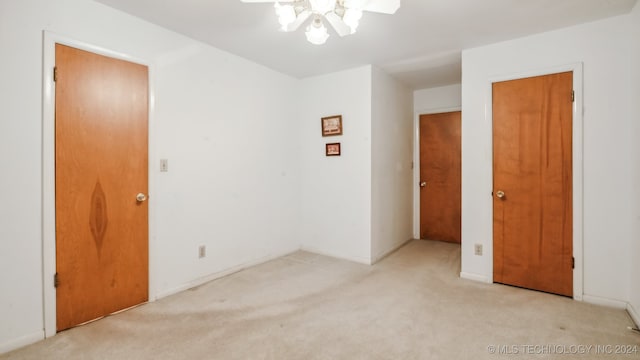 carpeted spare room with ceiling fan