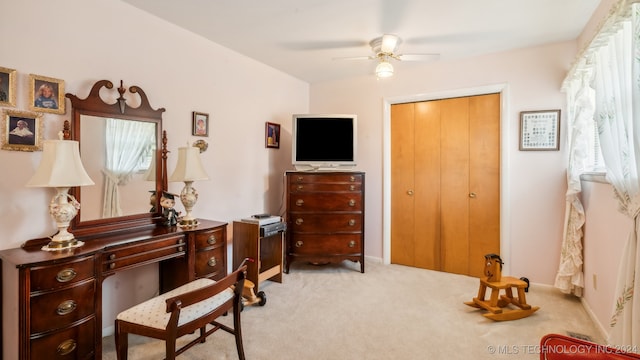 interior space featuring light carpet and ceiling fan