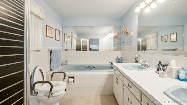 bathroom with toilet, vanity, and tiled bath