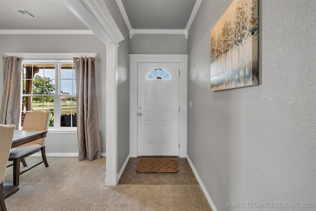 carpeted foyer featuring ornamental molding