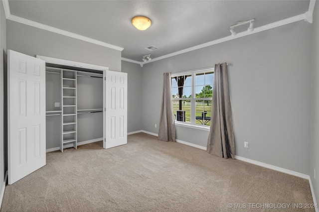 unfurnished bedroom featuring carpet, a closet, and crown molding