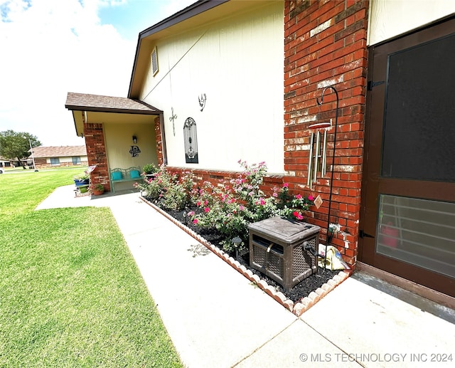 view of exterior entry featuring a lawn