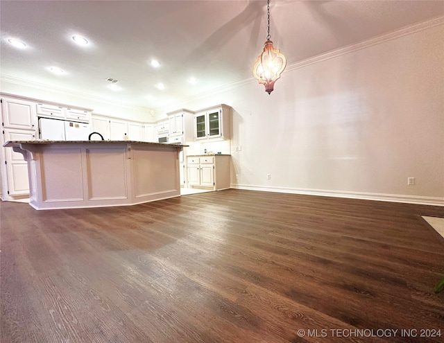 kitchen featuring white cabinetry, white refrigerator, ornamental molding, a kitchen breakfast bar, and dark hardwood / wood-style flooring